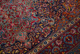 Elaborate cloudband and palmette motifs in gem-like ruby and sapphire on a fine Kashan rug.