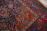 Collector Persian Kashan rug corner with intricate palmettes and vines in vivid gem-like hues.