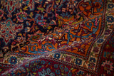 A fold revealing the intricate cloudband motifs and vivid gem-like colors of this collector Kashan rug.