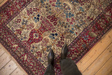 An antique Isfahan rug showing its ivory Tree of Life field beside the cochineal red pictorial border.