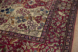 Perched bird and multi-colored blossoms on the ivory field of an antique Isfahan collector rug.