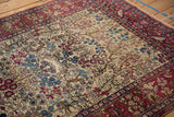 A leopard with prey and birds in the cochineal red forest border of a fine antique Isfahan rug.