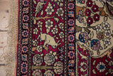 Ivory rabbit pictorial motif in the cochineal red border of a fine antique Isfahan rug.