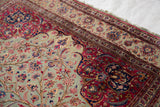 Intricate cochineal red border and jade green field of an antique Qajar silk Kashan rug.