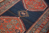 Antique Bijar rug's abrashed dark navy blue field with madder red zigzag border.