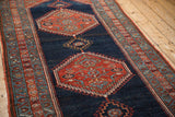 Hand-knotted antique Bijar rug showing a madder red hexagonal medallion with dusty teal hook-and-latch motifs.