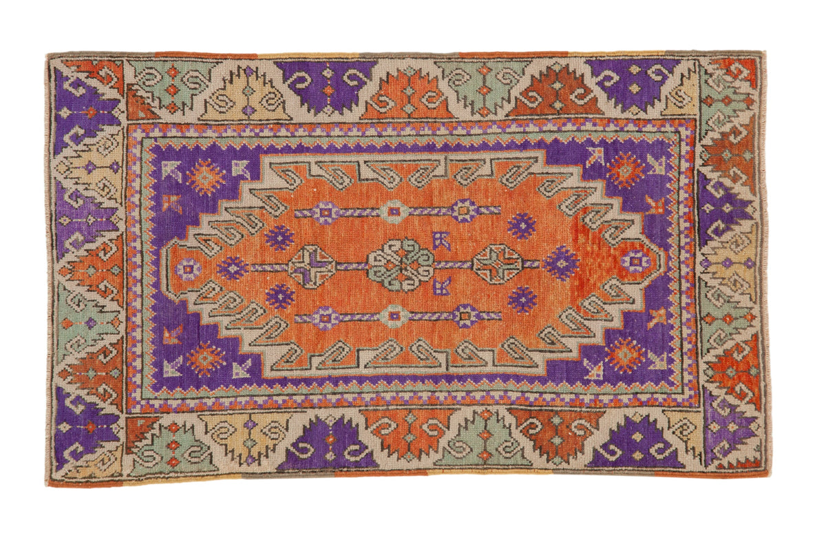Vintage distressed Oushak rug with interconnected geometric columns in terracotta, aubergine, and sea foam green.