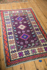 Distressed aubergine field and geometric orange, ivory quatrefoil borders of a vintage Oushak rug.