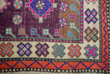Distressed aubergine Oushak rug, with colorful geometric quatrefoil motifs and checkered border.