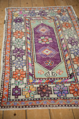Distressed Oushak runner with aubergine medallion, seafoam green, and colorful finned floral borders.