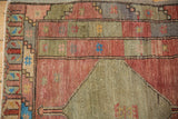 Vintage distressed Oushak rug detail: sage green and terra cotta panels with sky blue highlights.