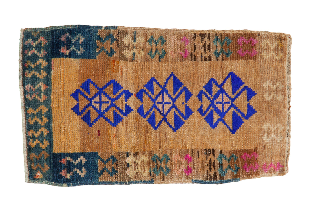 Vintage distressed Kars rug with three bold cobalt blue medallions on a textured camel and sand field.