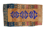 Vintage distressed Kars rug with three bold cobalt blue medallions on a textured camel and sand field.