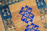 Vibrant royal blue gul medallion on the distressed, camel-colored, hand-knotted pile.
