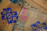 Back of a distressed Kars rug showing its hand-knotted foundation and intact side cord.