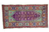 Distressed vintage Oushak runner with a tree of life design in aubergine, mint green, and tangerine orange.