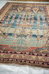 Perspective view of a Qajar period Kermanshah carpet's Tree of Life composition and intricate floral borders.