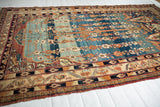 Angled view of an antique Kermanshah rug displaying the luminous Kork wool pile and full design layout.