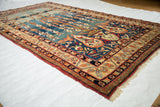 Perspective shot of an antique Kermanshah rug revealing the silky sheen of its natural dyed pile.