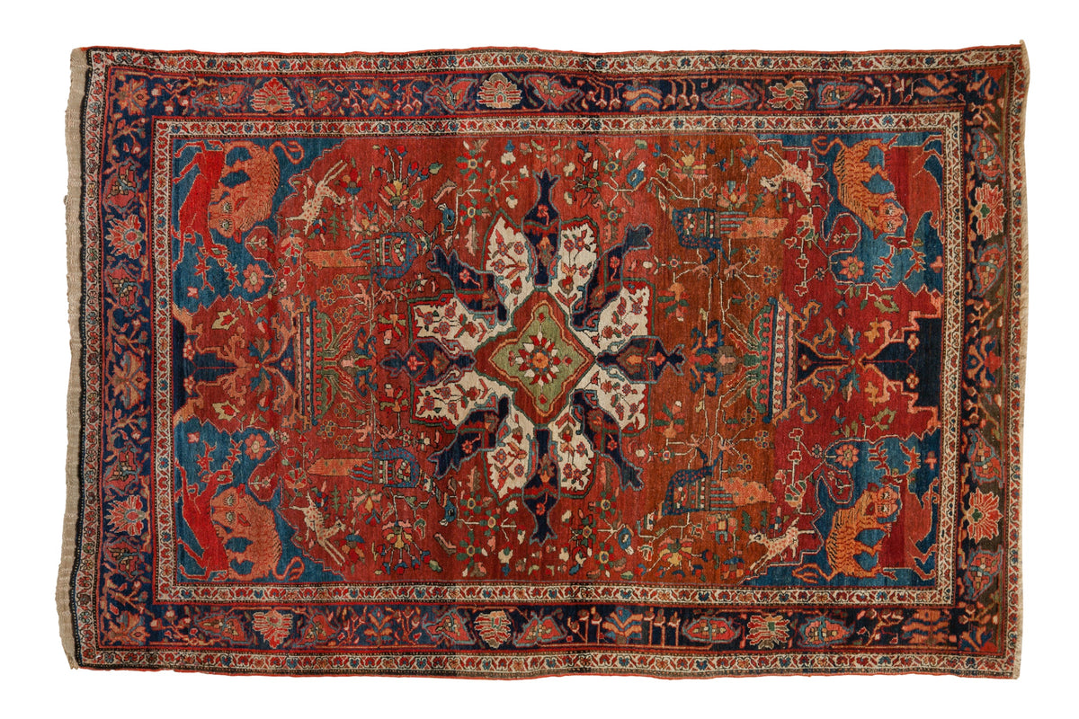 Antique Farahan Sarouk rug with a medallion, pictorial animals on a rust field, and a deep indigo border.