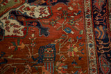 A blue architectural urn and floral vinery on the madder root field of a collectible Persian rug.