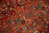 Close-up of the antique rug's forest scene with hand-knotted birds perched among dense floral vines.