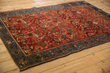 Angled view of an antique Farahan Sarouk rug's detailed floral and bird design.