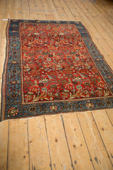 Angled perspective of an antique Farahan Sarouk rug showing its gem-toned, repeating forest scene design.