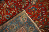 Corner detail of an antique Persian rug showing its hand-knotted foundation and rich red pile.