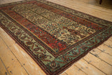 Angled view of an antique Fereghan carpet highlighting its full Tree of Life design.