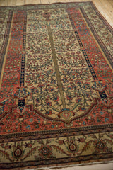 Refined Tree of Life pattern and floral borders of an antique Fereghan carpet seen from a low angle.