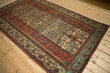 High-angle view of an antique Fereghan carpet's full Tree of Life design and wide floral borders.
