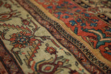 The low, even pile of an antique Fereghan carpet showing time-softened terracotta and ivory dyes.