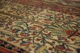Angled close-up of the antique Fereghan carpet's low pile, showing even wear to the knot heads.