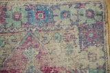 Distressed vintage Oushak rug detail: worn pile and visible foundation in blue, green, and purple.