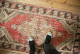 Vintage distressed Oushak rug runner showing its scale and worn texture from above.
