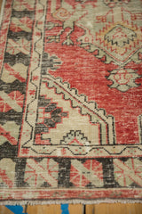 Decorative worn texture on a vintage Oushak rug with a serrated border in red and charcoal.