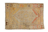 Distressed vintage Oushak rug with central medallion, saffron, terracotta, and ivory colors, visible abrash.