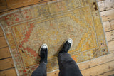 Worn pile of vintage distressed Oushak rug with saffron, terracotta geometric motifs.