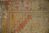 Distressed Oushak rug detail showing abrash on saffron yellow, terracotta stepped pattern.