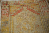 Distressed pile texture with saffron yellow and terracotta geometric patterns on an Oushak rug.