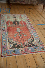 Distressed pile of a vintage Oushak rug with faded brick red and pale blue serpent border.