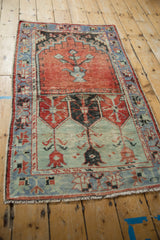 Distressed vintage Oushak rug detail: seafoam green field, faded geometric patterns, blue border.