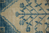 Vintage distressed Oushak rug close-up: simplistic blue geometric floral motifs on ivory.