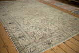 The distressed, low pile of a vintage Turkish Kayseri carpet with scrolling vines and dusty rose blossoms.