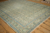 Angled view of a distressed Kayseri carpet highlighting its repeating trellis design and vine border.