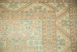 Detail of the serrated leaf main border and serpent minor border in sea foam, terracotta, and brown.