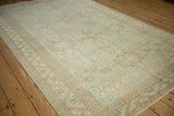 Angled view of a distressed Sparta carpet with repeating geometric shield medallions.
