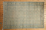 Corner detail of a distressed Sparta rug showing its machine-bound edge and geometric borders.