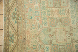 Worn texture of the vintage Sparta carpet's geometric borders in sea foam and terracotta.